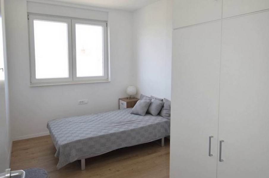 Druhá ložnice s postelí a šatní skříní