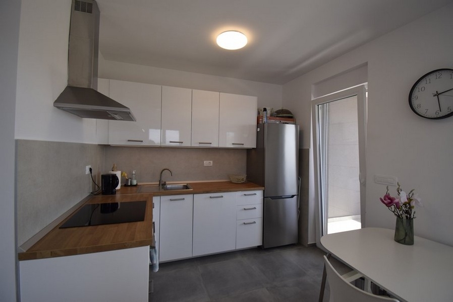 Moderní kuchyňská linka s vestavěnými spotřebiči a jídelním stolem