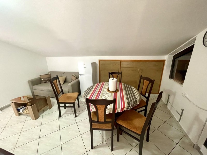 Obývací a jídelní kout se sedací soupravou, lednicí a stolem