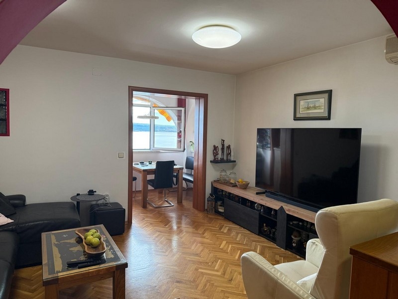 Obývací pokoj s TV a výhledem na moře v pozadí