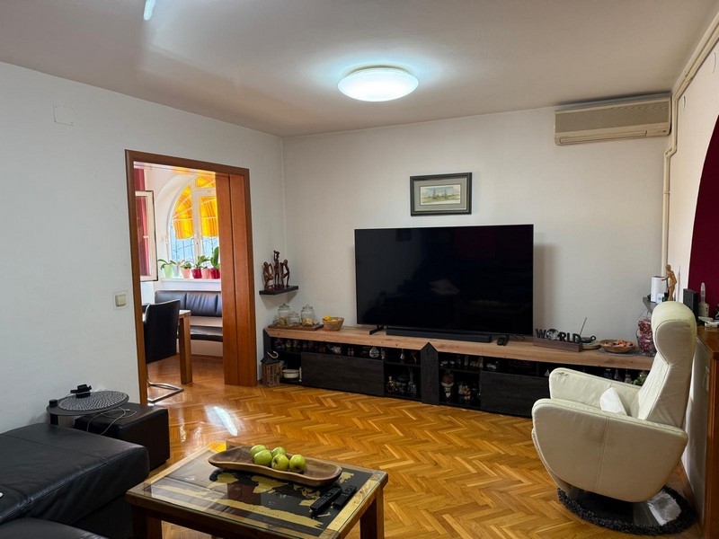 Obývací pokoj s velkou TV a klimatizací