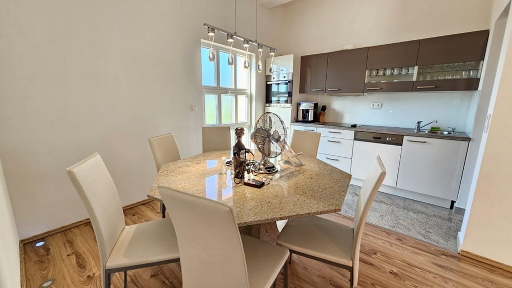 Jídelna s velkým stolem a kuchyní