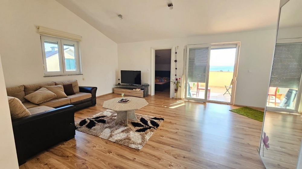 Obývací pokoj se vstupem na balkon a výhledem na moře