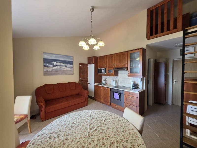 Obývací prostor s kuchyní, pohovkou a galerií v Chorvatsku