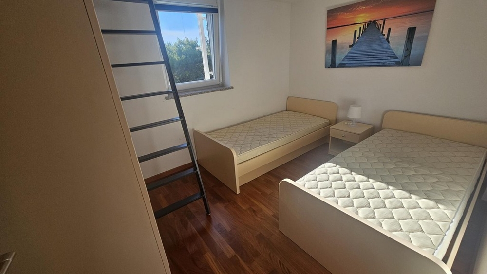 Dětský nebo pokoj pro hosty se dvěma samostatnými lůžky a žebříkem na galerii