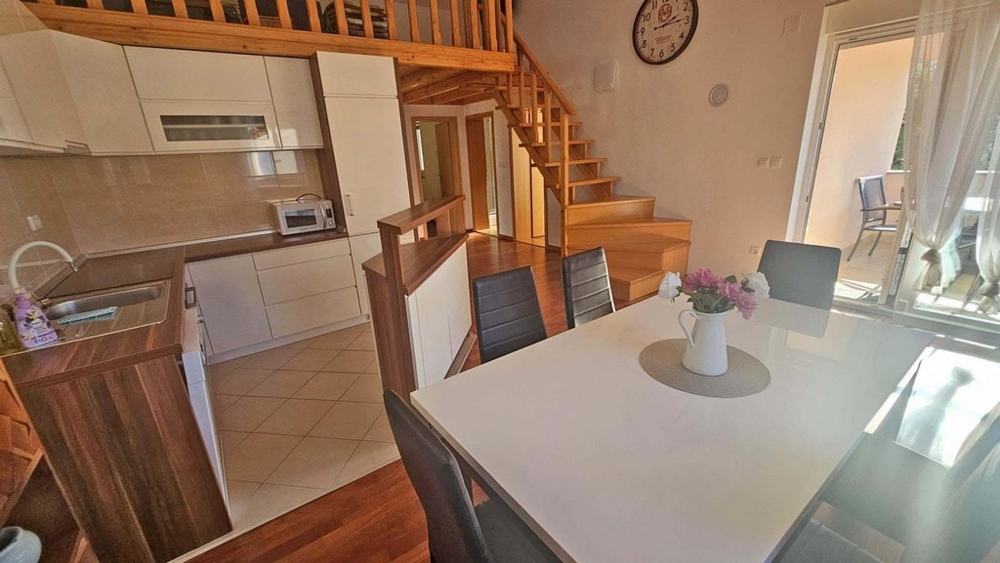 Pohled na jídelní kout, kuchyň a schodiště na galerii