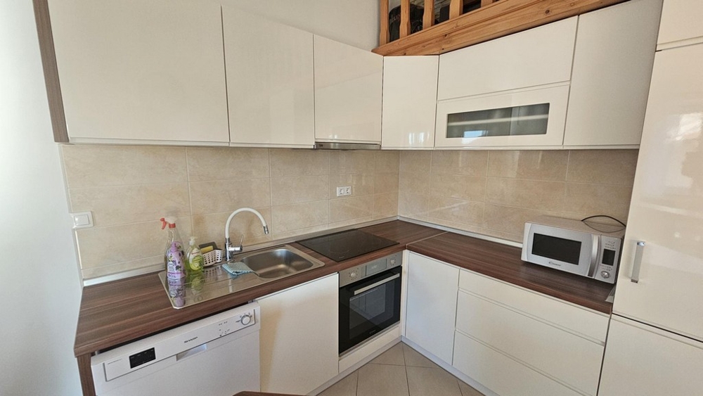 Moderní zařízená kuchyně s elektrospotřebiči a pracovní plochou