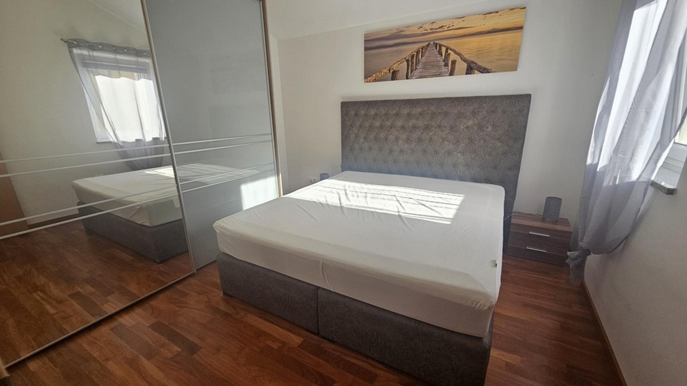 Ložnice s manželskou postelí a velkou zrcadlovou skříňkou