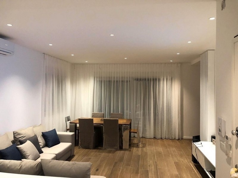 Světlý obývací pokoj s pohovkou a jídelním koutem