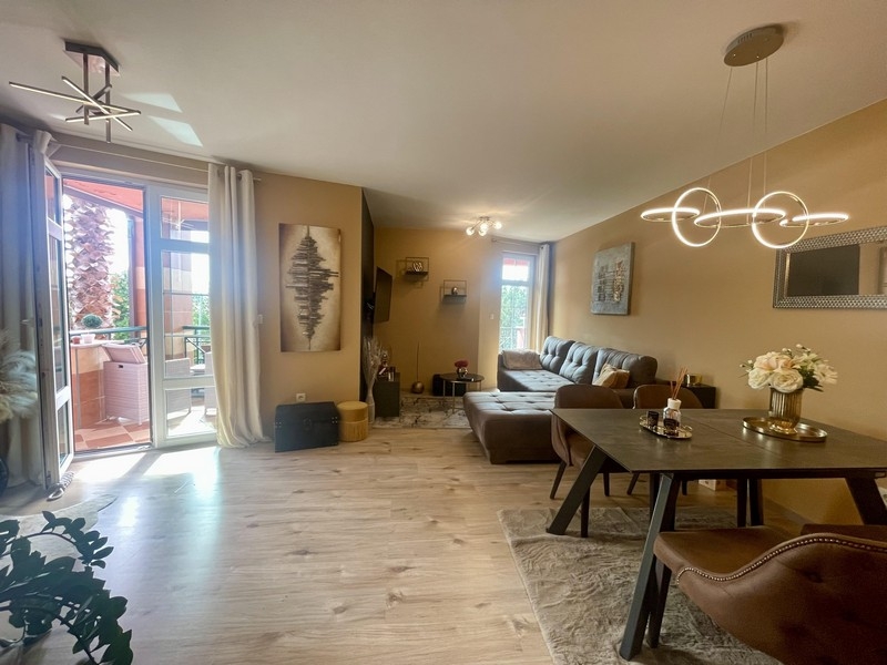 Světlý obývací pokoj s jídelním koutem, pohovkou a vstupem na terasu