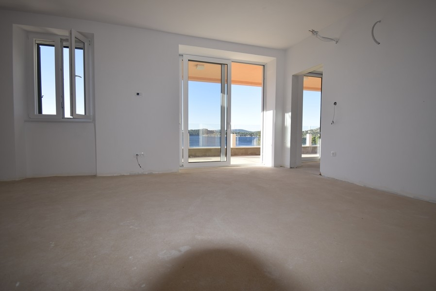 Obývací pokoj s panoramatickými okny a výhledem na moře