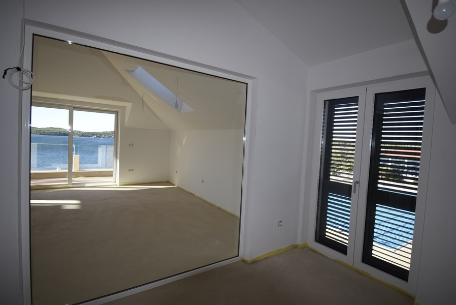 Ložnice s prosklenou stěnou a vstupem na balkon