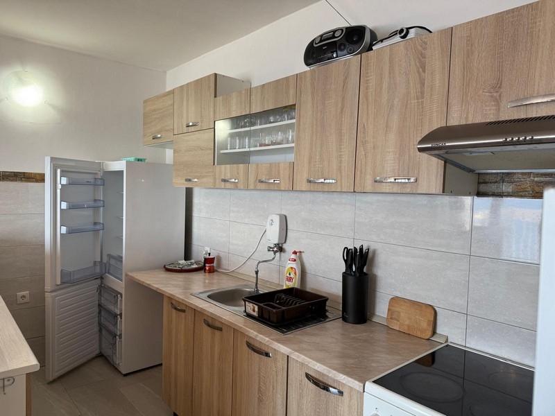 Moderní kuchyně s dřevěnými čely a dlážděnou zadní stěnou