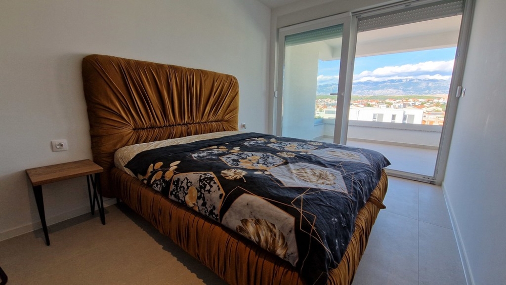 Ložnice se vstupem na terasu a výhledem na hory