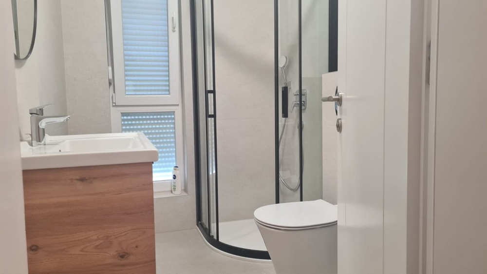 Moderní koupelna se sprchovým koutem a dřevěným umyvadlem