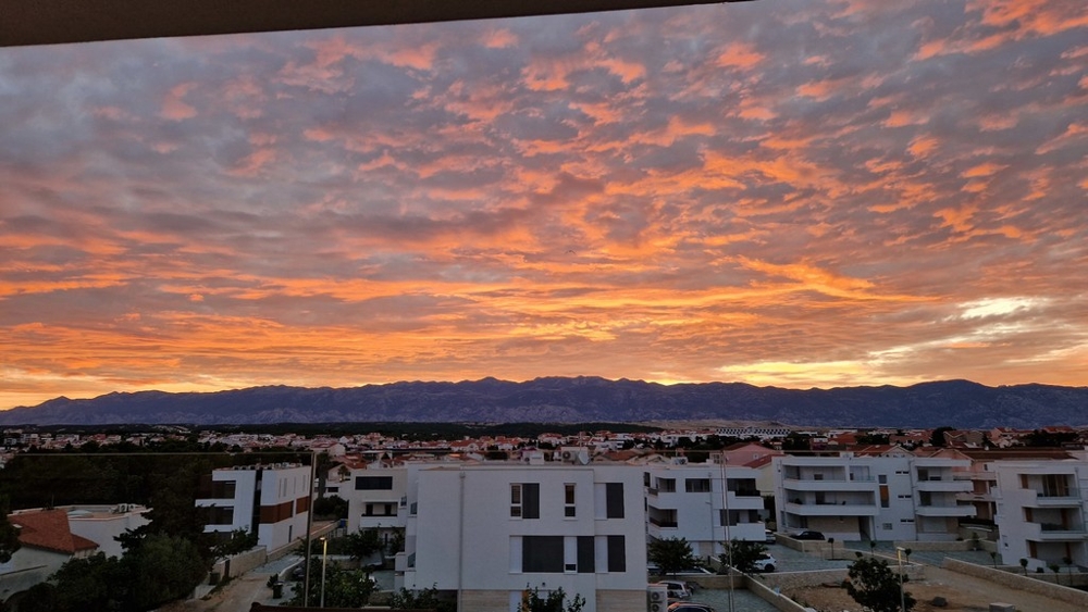 Večerní atmosféra nad Novaljou s výhledem na pohoří Velebit