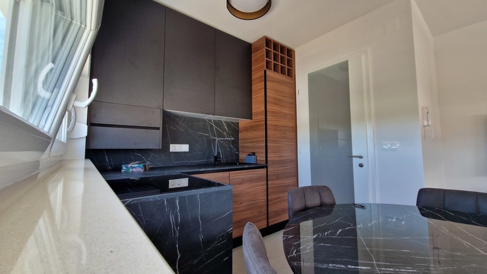 Moderní kuchyně v tmavém provedení s dřevěnými prvky