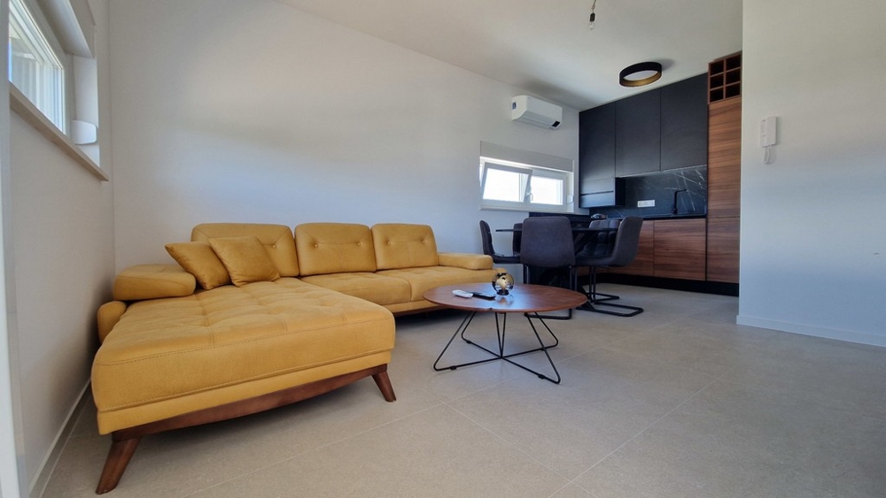 Obývací pokoj se žlutou pohovkou a jídelním koutem