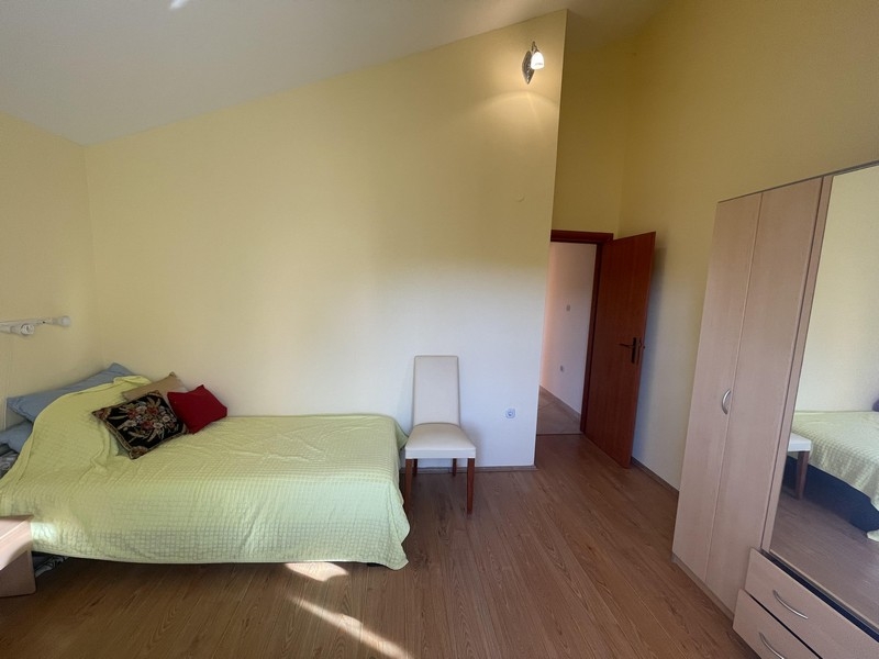 Světlá ložnice s šatní skříní a posezením
