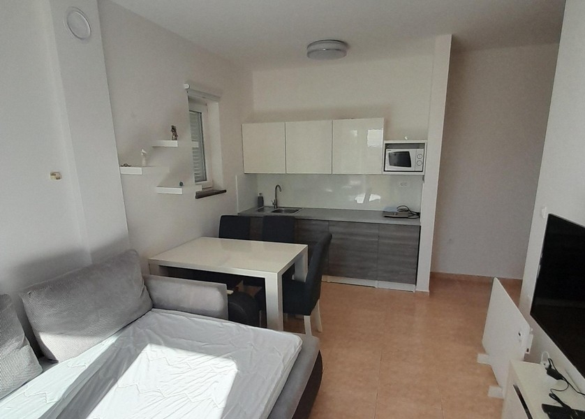 Moderní kuchyňský kout s horními a spodními skříňkami a jídelním koutem