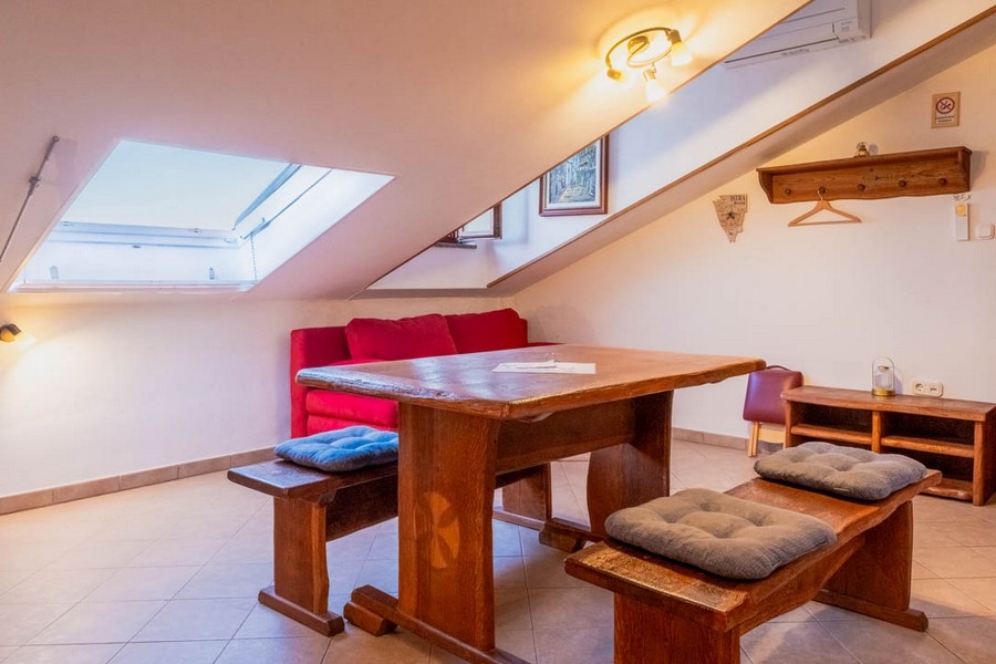 Obývací pokoj se zkoseným stropem a dřevěným nábytkem