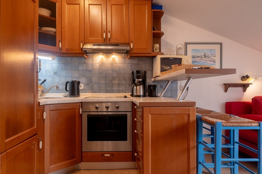 Kuchyně s dřevěnými dvířky a plně vybavená