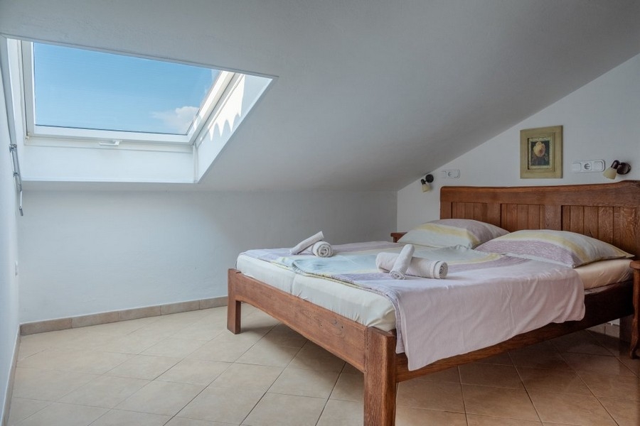 Ložnice s manželskou postelí a střešním oknem