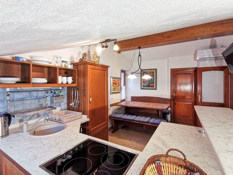 Kuchyně s dřevěnými dvířky a plně vybavená