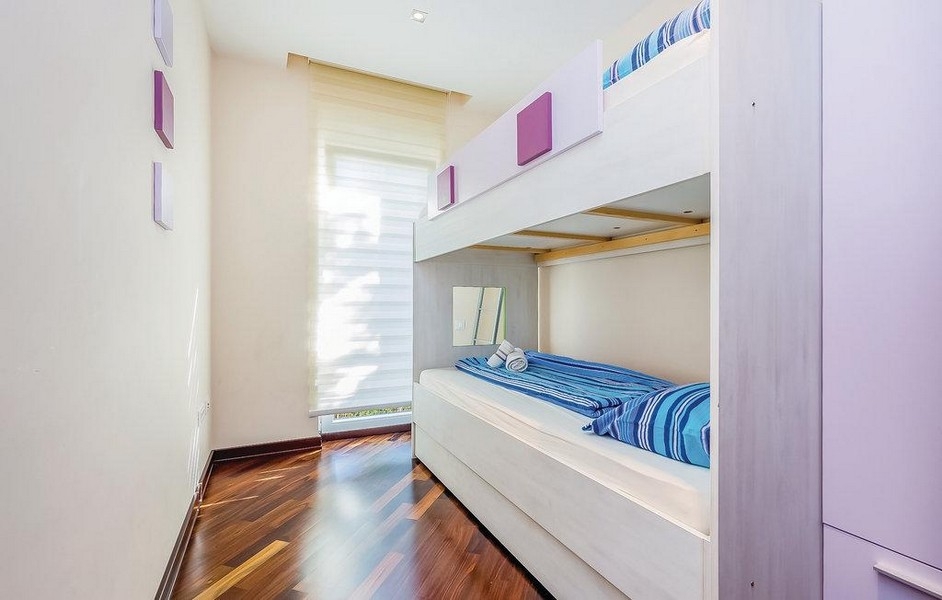 Dětský pokoj s patrovou postelí a dřevěnou podlahou