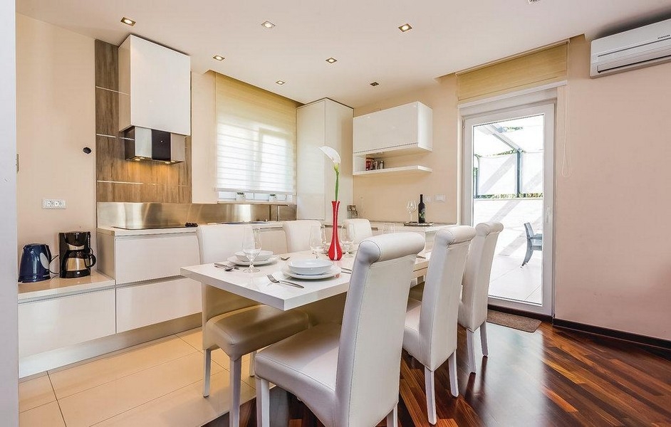 Moderní kuchyně s jídelním koutem a vstupem na terasu