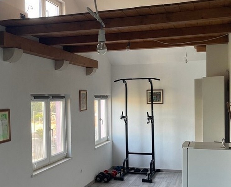 Fitness zóna pod dřevěnými trámy v obývacím pokoji