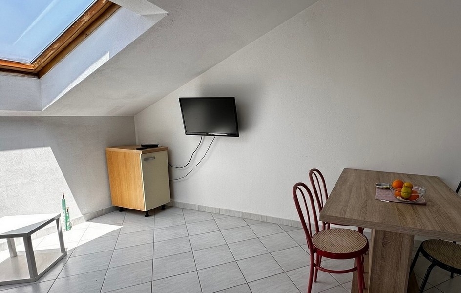 Obývací pokoj s televizí a jídelním stolem