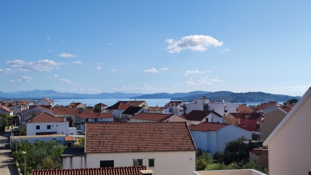 Široký výhled přes střechy směrem k moři