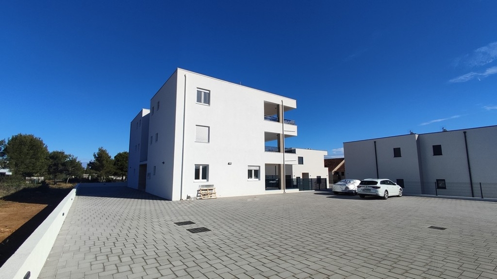 Vnější pohled na moderní bytový dům s parkovacími místy