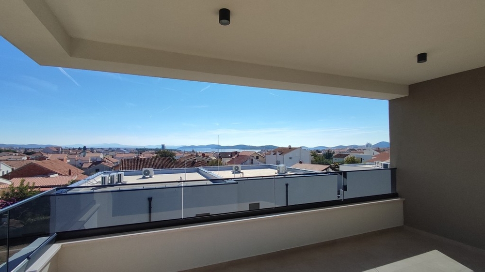 Široký výhled na střechy a moře z terasy