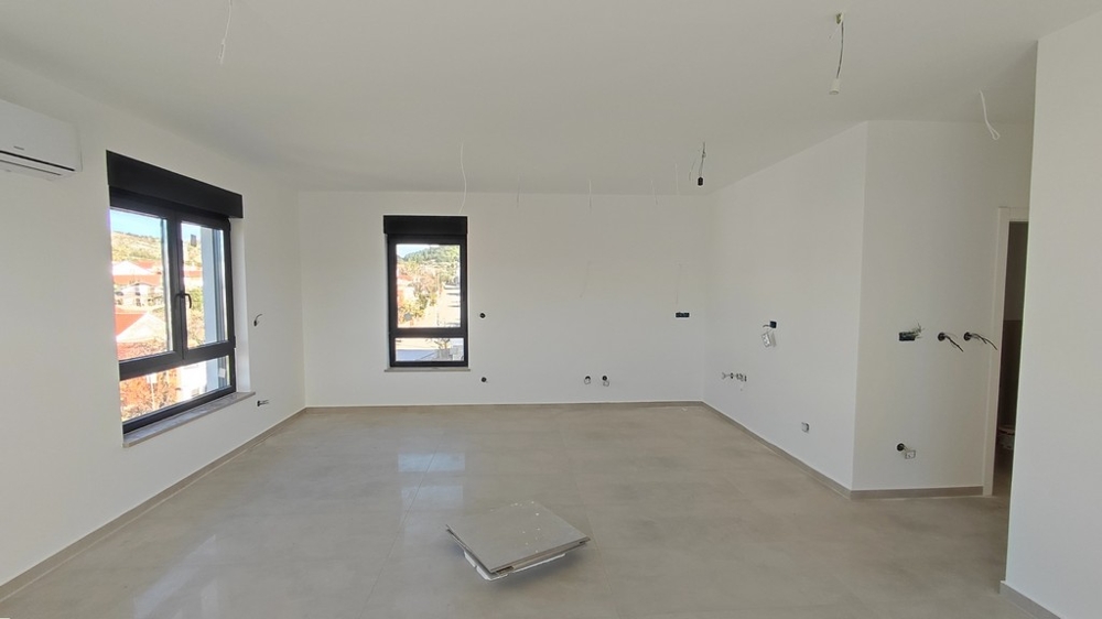 Světlý obývací pokoj nového bytu s velkými okny