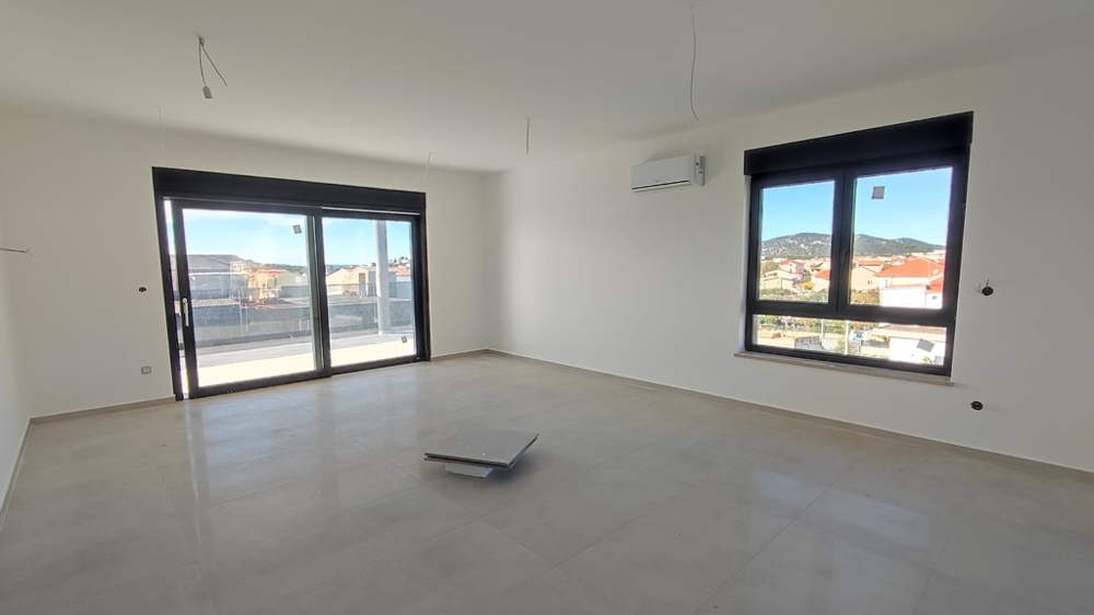 Obývací pokoj se dvěma okny a přípravou na kuchyň