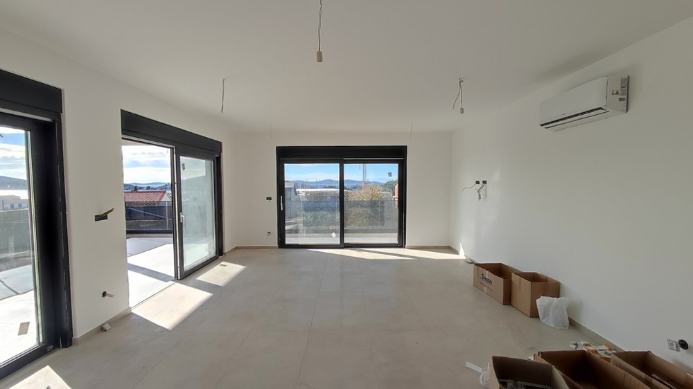 Prostorný obývací pokoj s výhledem na moře a přístupem na několik dveří na terasu