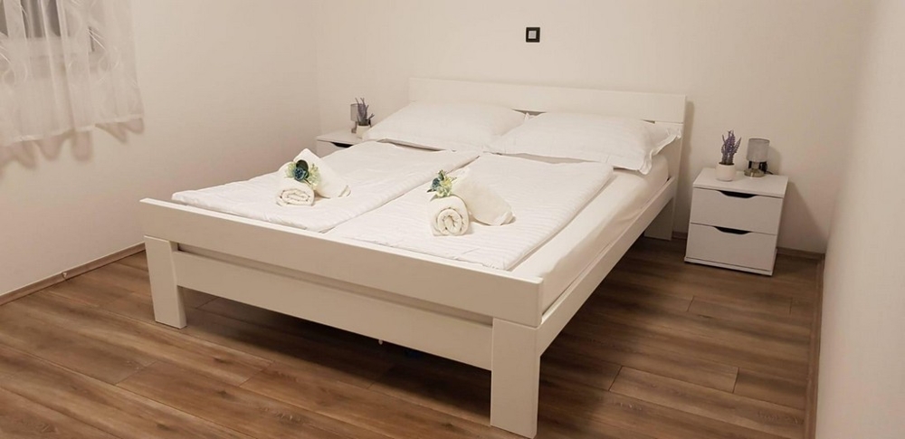 Ložnice s manželskou postelí a nočním stolkem