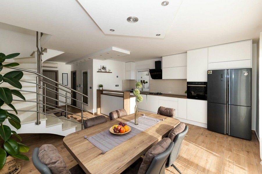 Otevřená kuchyně s jídelnou a schodištěm do horního patra