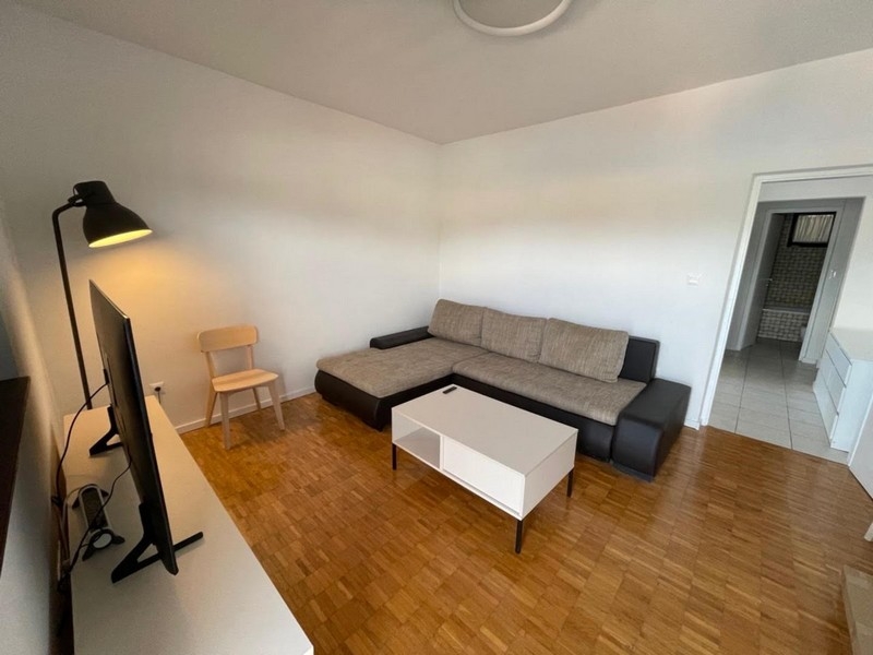 Obývací pokoj s rohovou pohovkou a TV