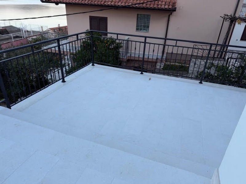 Terasa se zábradlím a výhledem na sousední dům