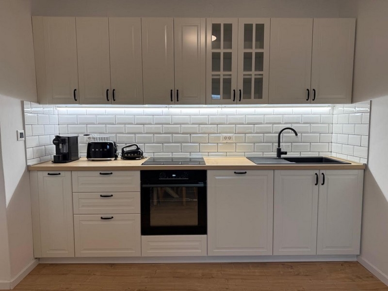 Světlá kuchyně s bílým vestavěným nábytkem