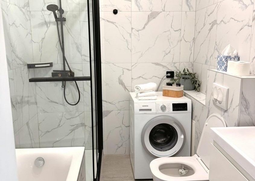 Moderní koupelna se sprchovým koutem a pračkou