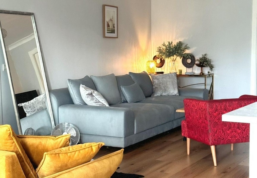 Posezení s velkým zrcadlem a šedou pohovkou