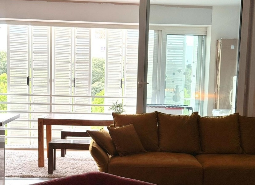 Žlutá pohovka před zasklenou lodžií