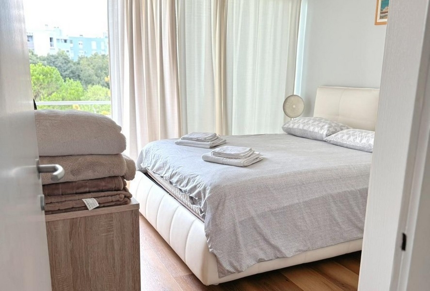 Ložnice s manželskou postelí a světelnými závěsy