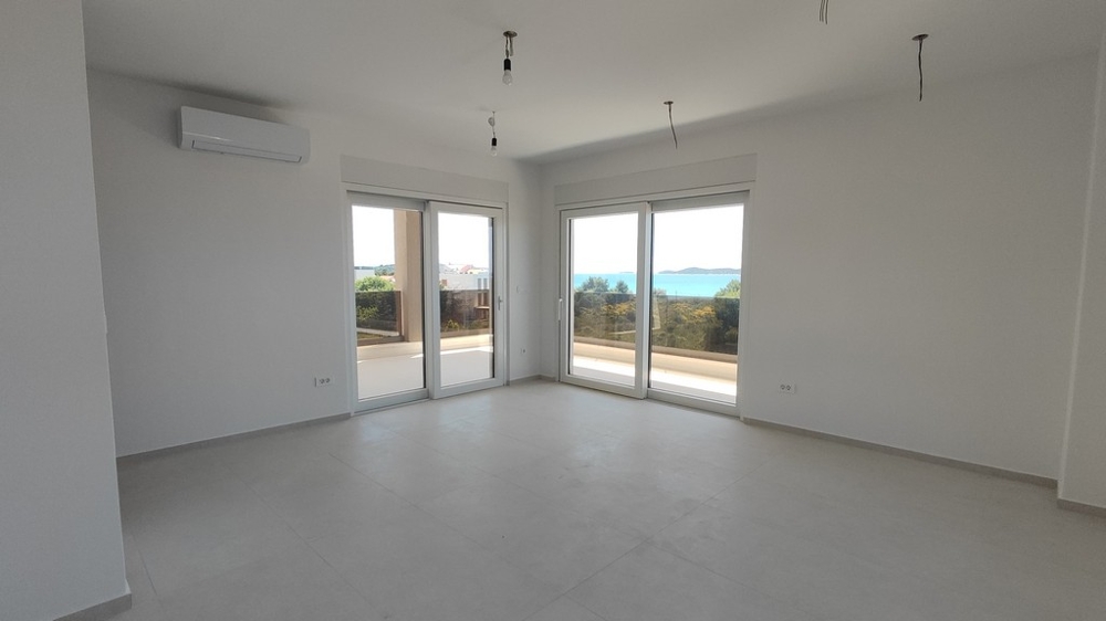 Obývací pokoj s velkými okny a výhledem na moře