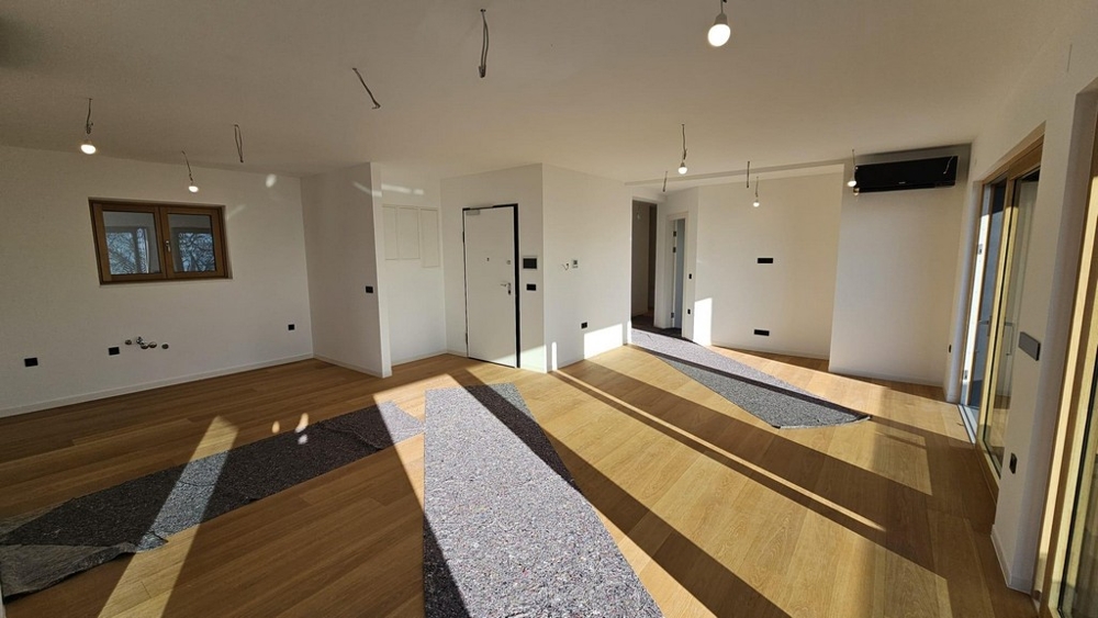 Otevřený obývací prostor s oknem a vstupem na terasu