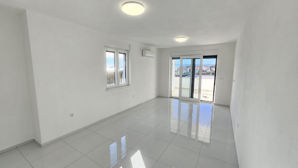 Světlý obývací pokoj se vstupem na balkon